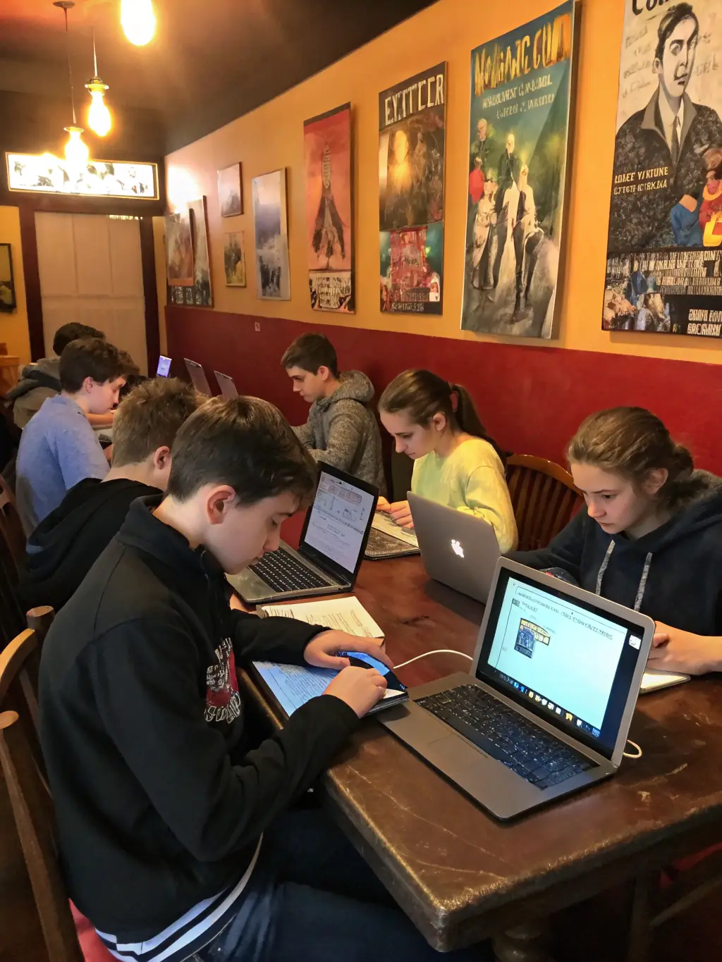 Teenagers working on a collaborative project in the OCB library's dedicated teen zone, surrounded by books and computers.